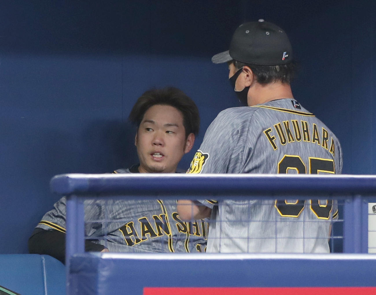 中日対阪神　7回裏を投げ終えベンチに戻った西勇（左）は福原コーチと言葉を交わし厳しい表情を見せる（撮影・前田充）