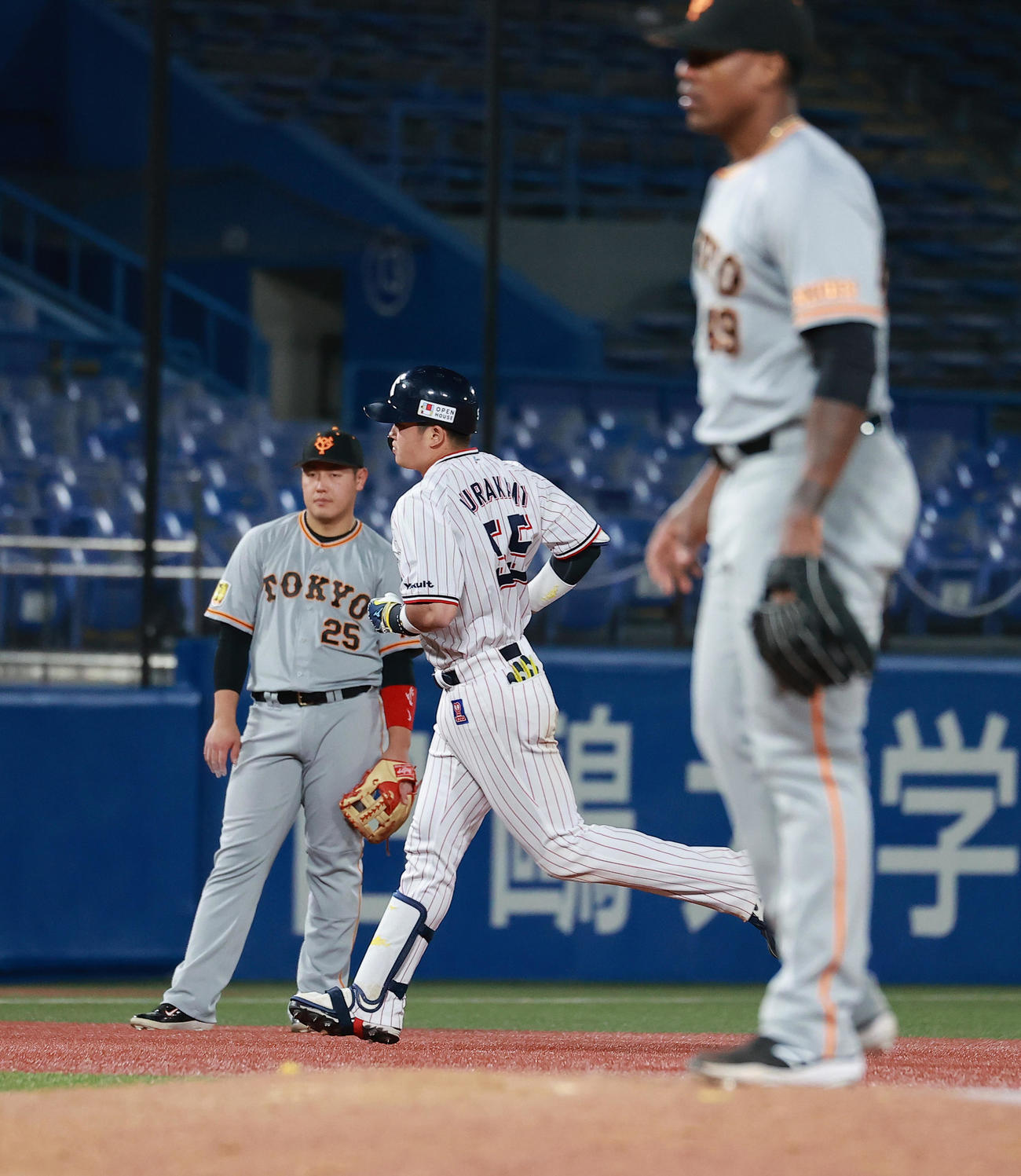 ヤクルト対巨人　9回裏ヤクルト1死一塁、ビエイラ（手前）から左中間2点本塁打を放ち三塁に向かう村上。奥左は岡本（撮影・野上伸悟）