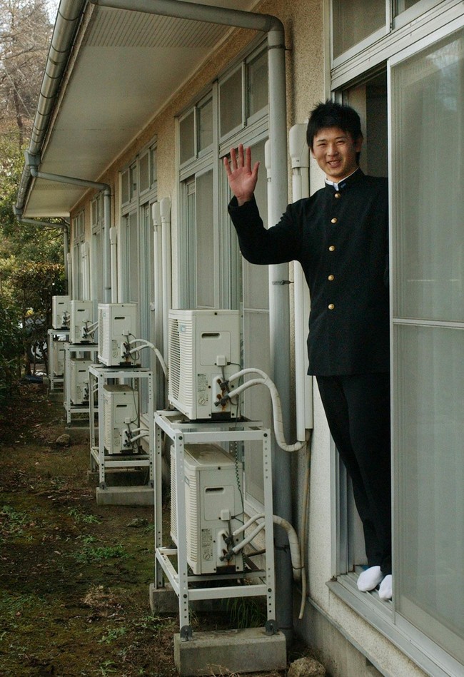 入寮した西武・涌井秀章は部屋から身を乗り出して報道陣に手を振る（05年１月９日）