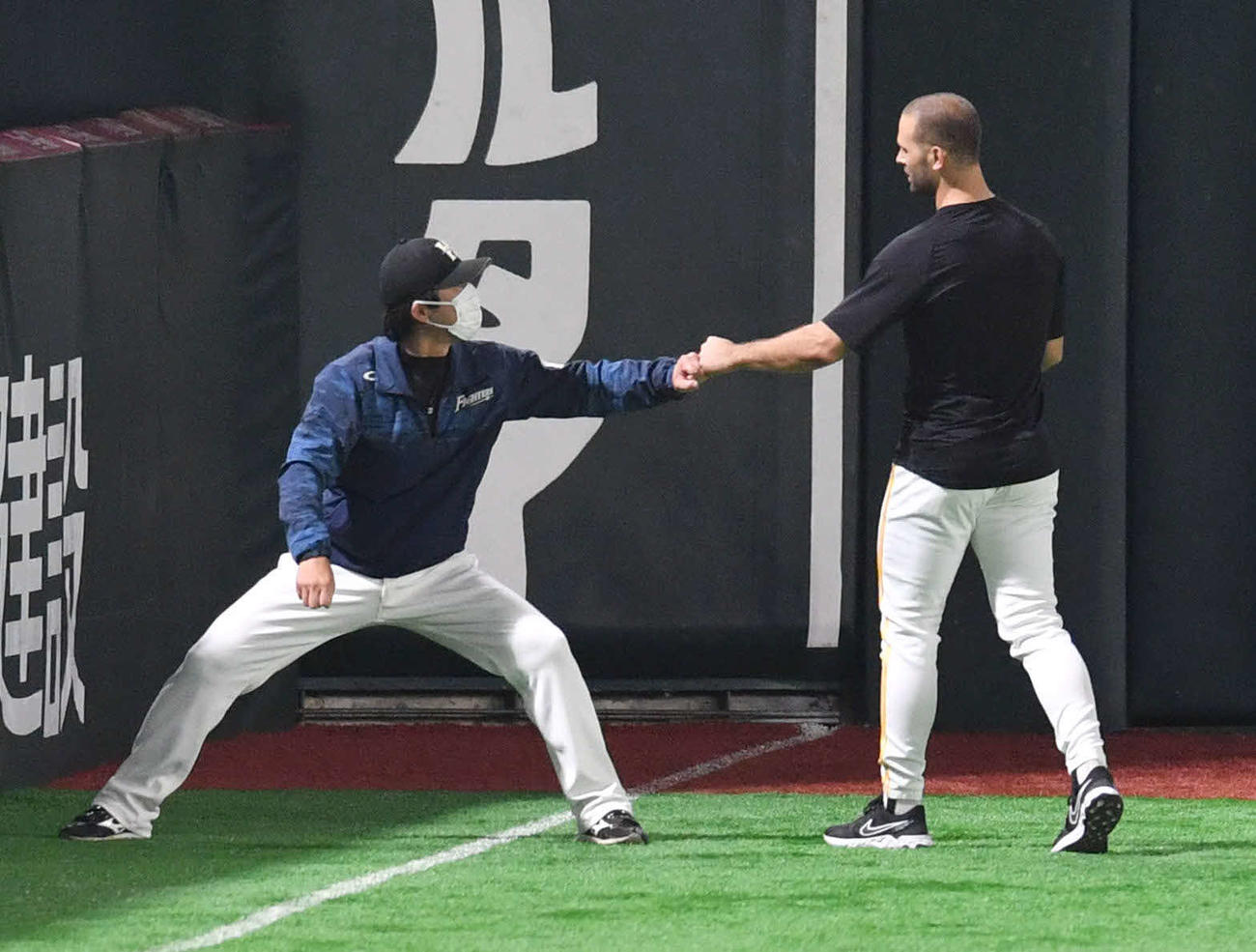 ソフトバンク対日本ハム　試合前、日本ハム小笠原ヘッドコーチとグータッチするソフトバンク・マルティネス（撮影・岩下翔太）