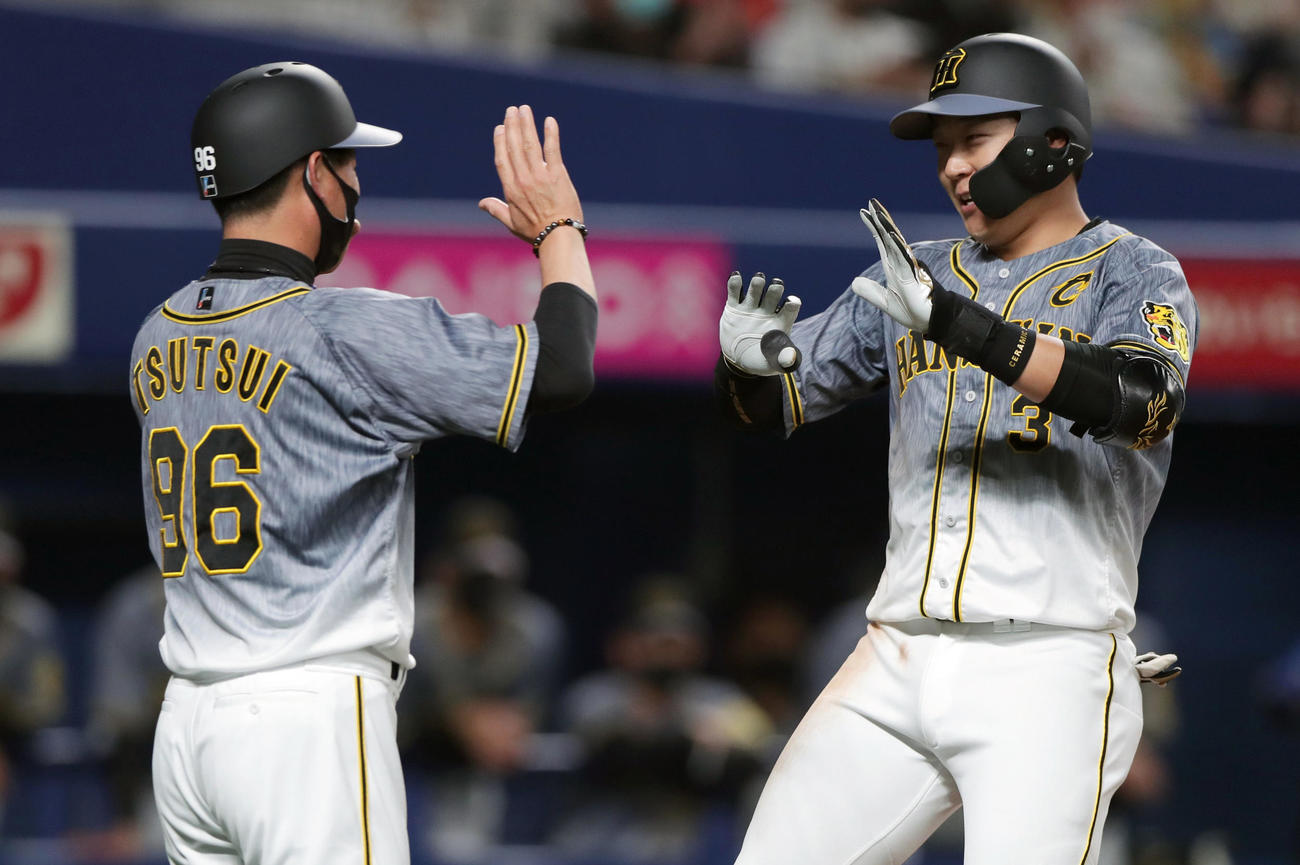 中日対阪神　3回表阪神1死一、二塁、左越え3点本塁打を放ち、迎えた筒井コーチ（左）と笑顔でタッチを交わす大山（撮影・前田充）