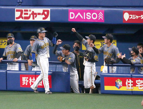中日対阪神　9回表阪神1死三塁、梅野（手前左）は中野の右適時二塁打で生還しベンチの出迎えを受ける（撮影・上山淳一）