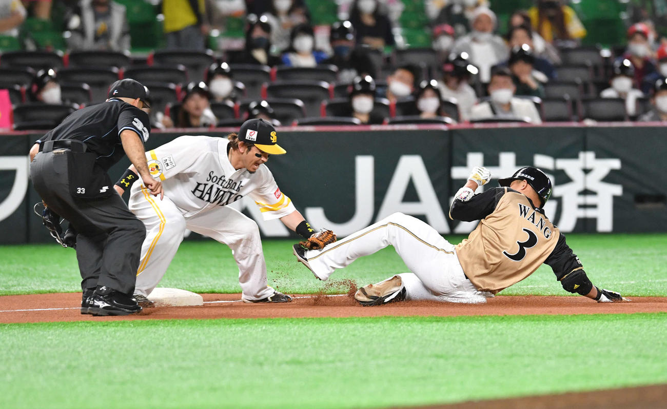 ソフトバンク対日本ハム　3回表日本ハム無死、中二塁打を放ち三塁を狙うもアウトとなった王柏融、左はソフトバンク松田宣浩（撮影・岩下翔太）