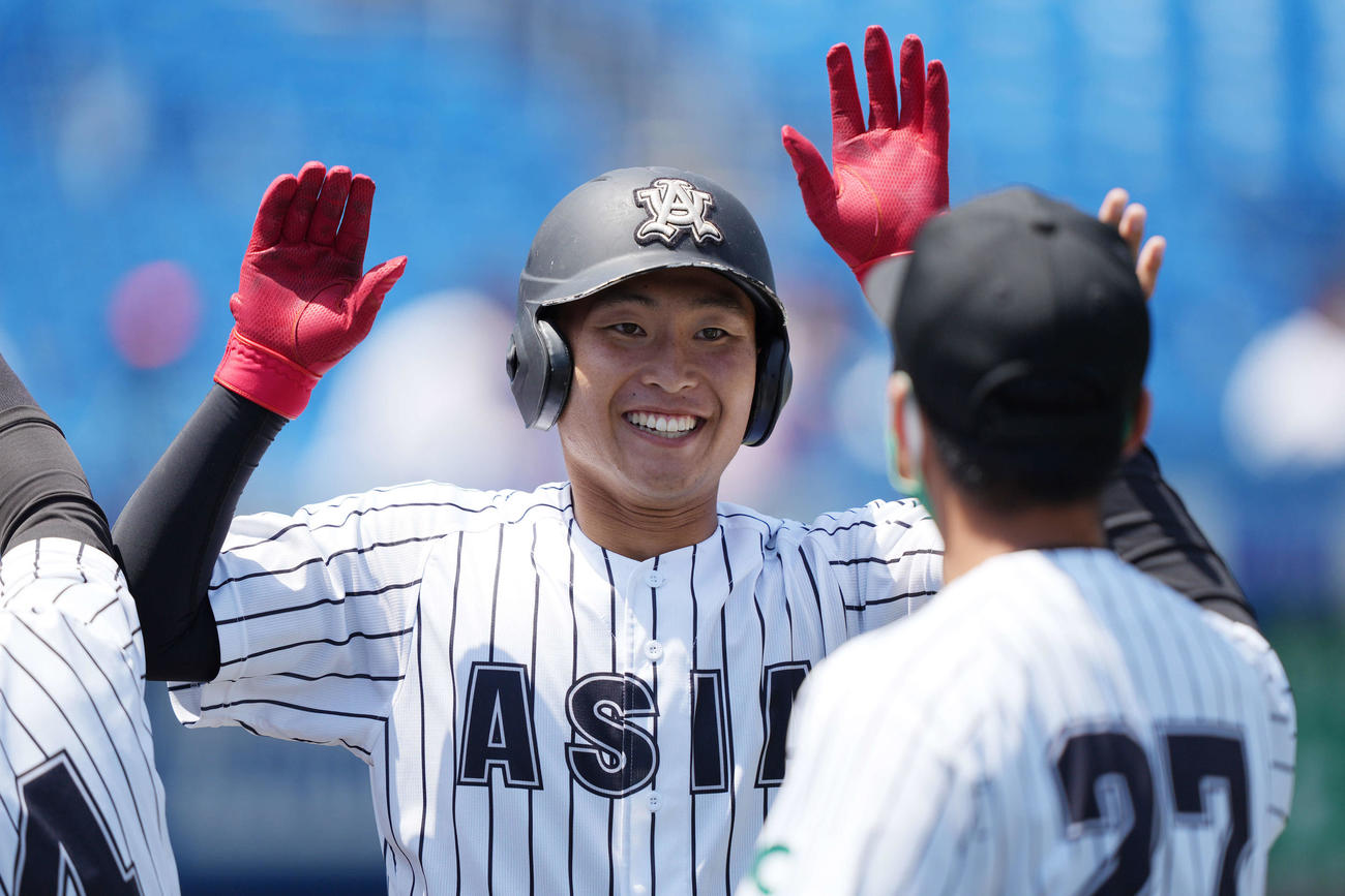 青学大対亜大　7回裏亜大1死、左越えソロ本塁打を放ち笑顔でナインとタッチを交わす大本（撮影・鈴木みどり）