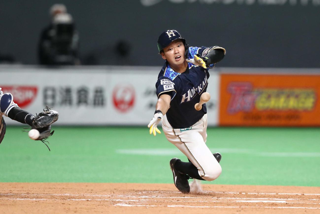 日本ハム対西武　3回裏日本ハム1死三塁、石川亮はスクイズを外され飛びつくも暴投となり走者石井が生還する（撮影・黒川智章）
