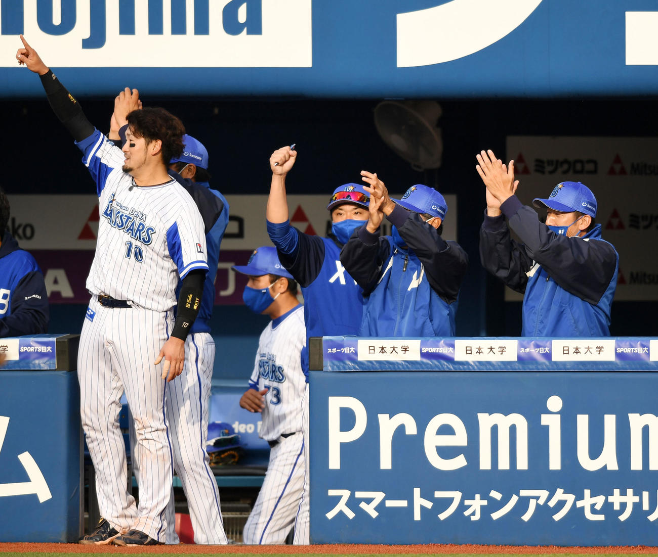 DeNA対ヤクルト　6回裏DeNA2死満塁、倉本の中前2点適時打で得点を奪い手をたたく三浦監督（右）らDeNAナイン（撮影・横山健太）