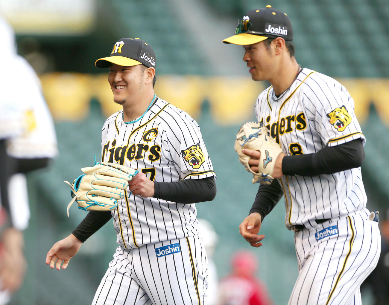 阪神対広島　7回途中で登板の岩貞（左）は無失点に抑えベンチの出迎えに笑顔を見せる（撮影・上山淳一）