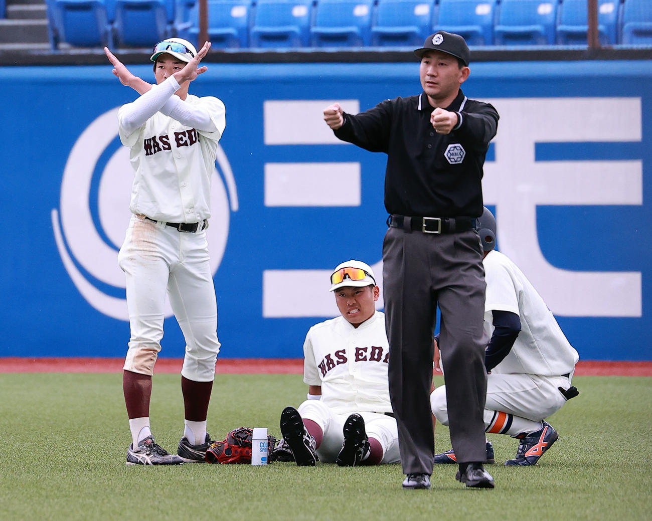 早大対法大　7回裏法大2死、小池の打球を追って左ひざを負傷した蛭間（中央）は痛そうな表情（撮影・浅見桂子）