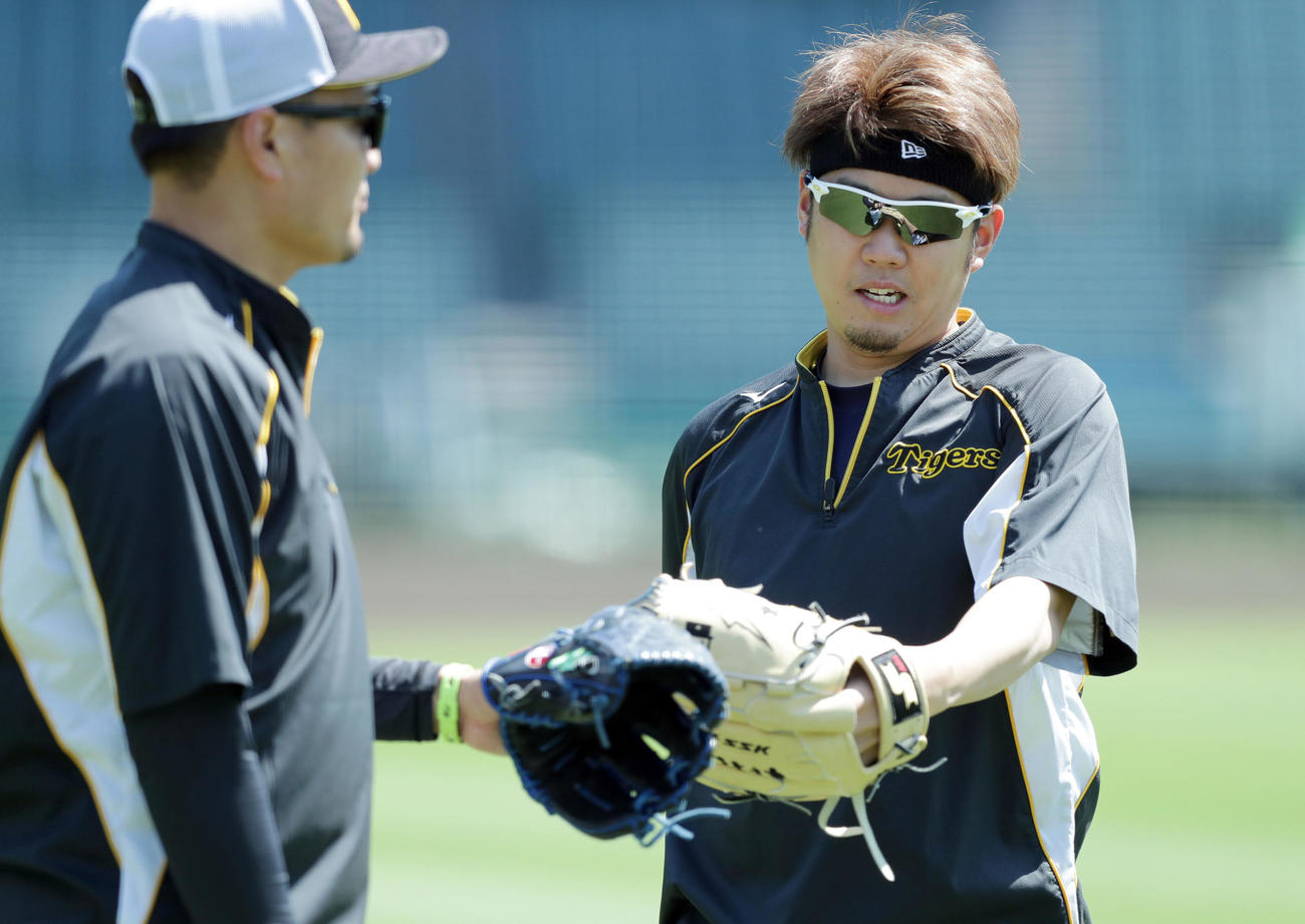 キャッチボールを終え阪神秋山（左）とグラブタッチする西勇輝（撮影・前田充）