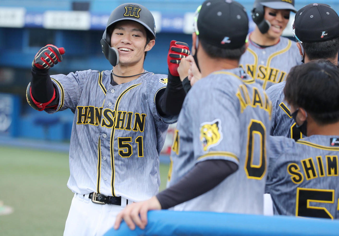 ヤクルト対阪神　8回表阪神1死二塁、右越え2点本塁打を放った中野（左）はナインに迎えられ笑顔を見せる（撮影・前田充）