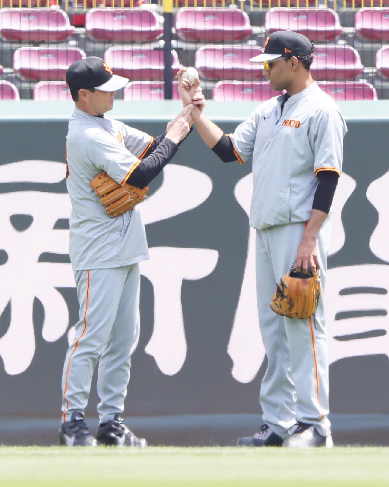 巨人サンチェス（左）に球の握りを指導する桑田投手チーフコーチ補佐（撮影・足立雅史）