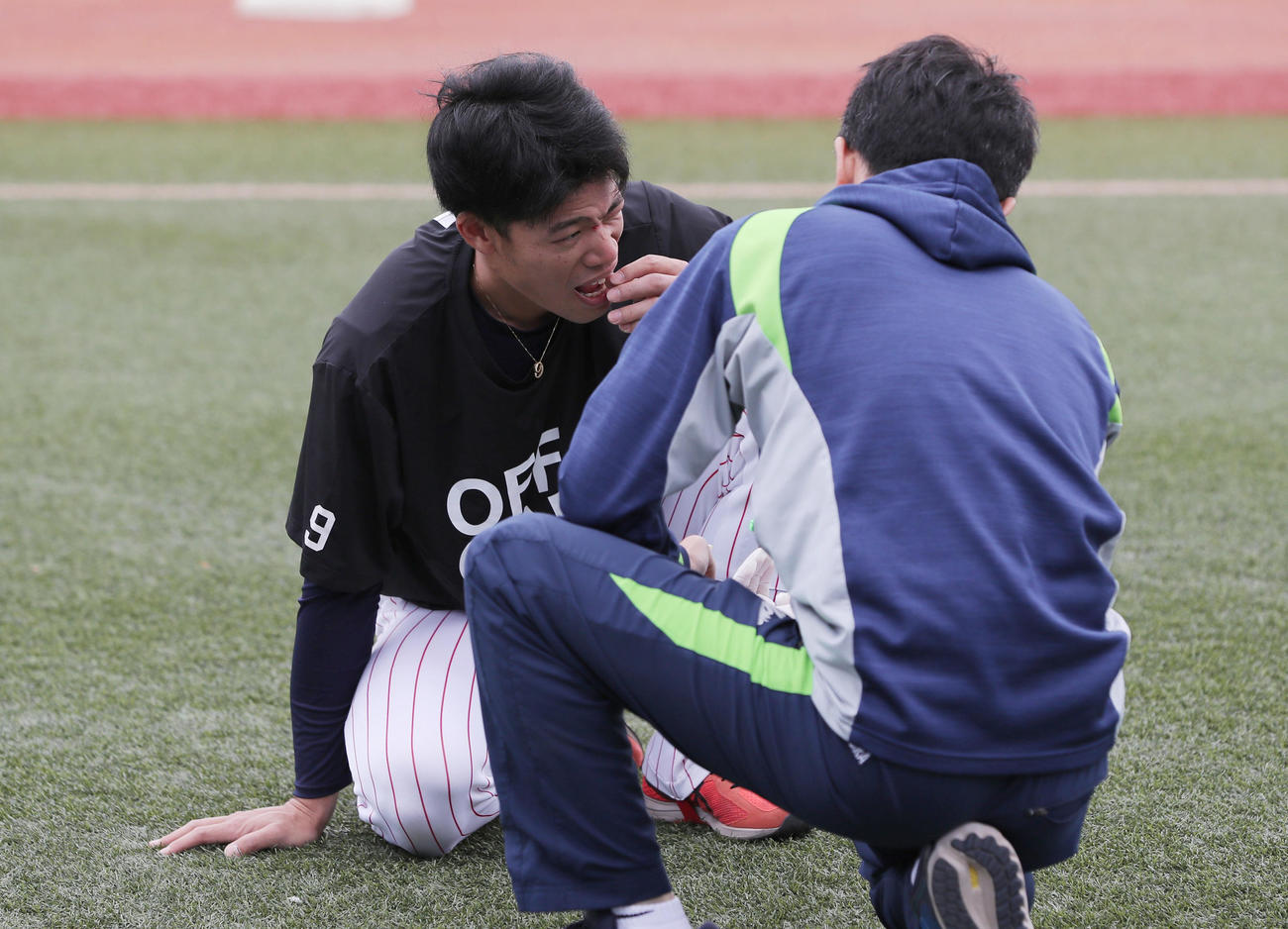ヤクルト対阪神　試合前練習でメディシンボールが顔面に直撃し歯が折れ痛がるヤクルト塩見（撮影・前田充）