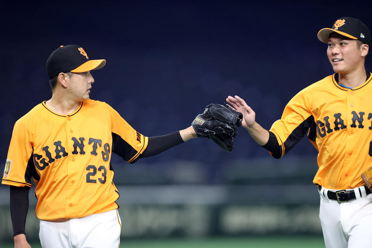 巨人対ヤクルト　7回表を終え、野上（左）とタッチを交わす坂本（撮影・狩俣裕三）
