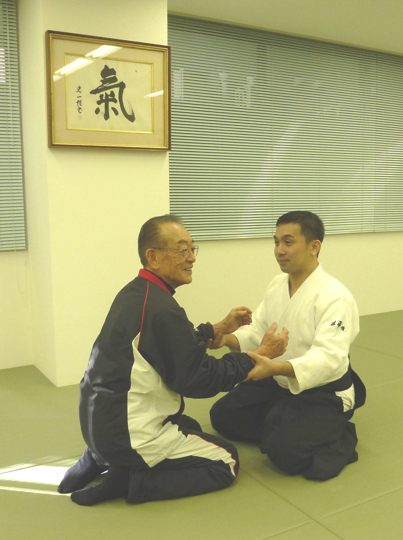 藤平信一会長（右）から指導を受ける広岡氏（心身統一合氣道会提供）