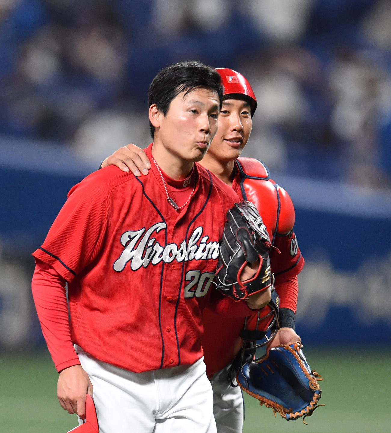 中日に勝利し安堵の表情の栗林は捕手の石原にねぎらわれる（撮影・森本幸一）