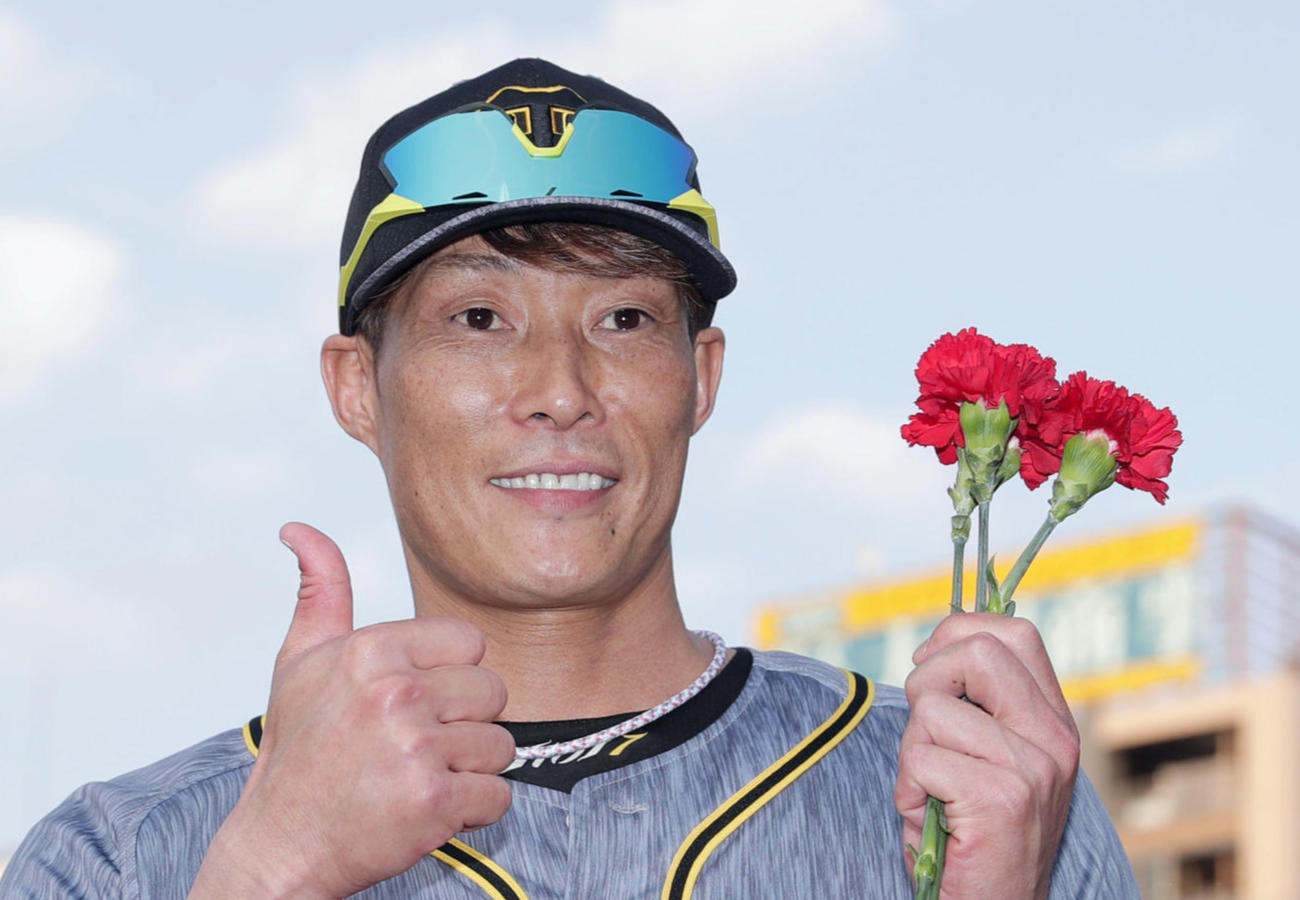 カーネーションを手に笑顔でサムアップポーズを決める阪神糸井（撮影・前田充）