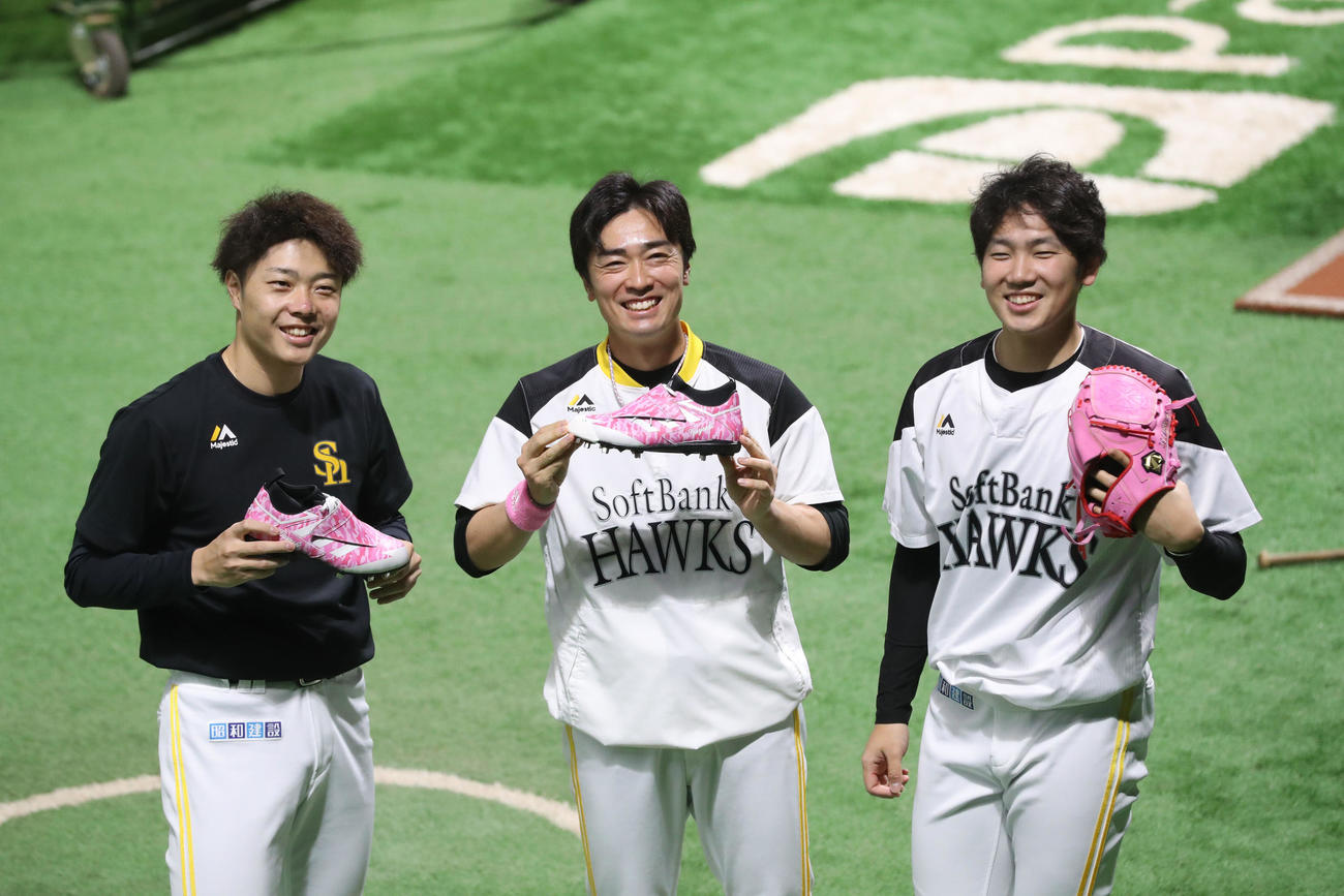 ソフトバンク対西武　ピンクのスパイクを持つ松本（左）と和田（中）と、ピンクのグローブを持つ石川（撮影・屋方直哉）