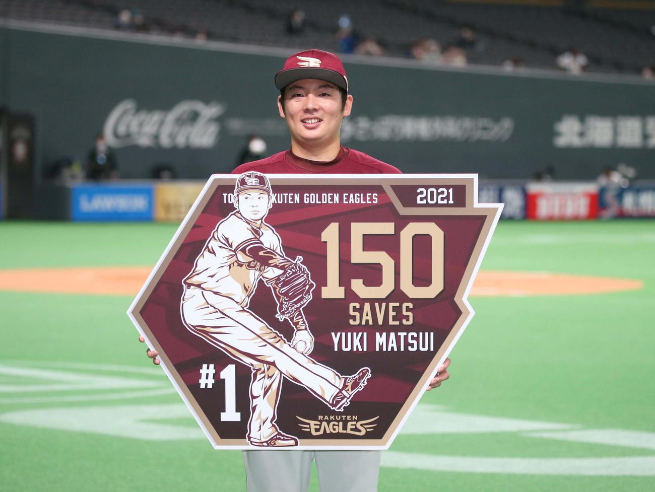 日本ハム対楽天　通算150セーブを達成し記念ボードを掲げる松井（撮影・黒川智章）