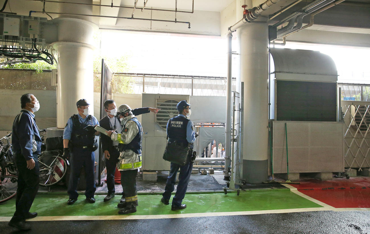 ぼやが発生した現場付近で説明を受ける警察と消防（撮影・前田充）