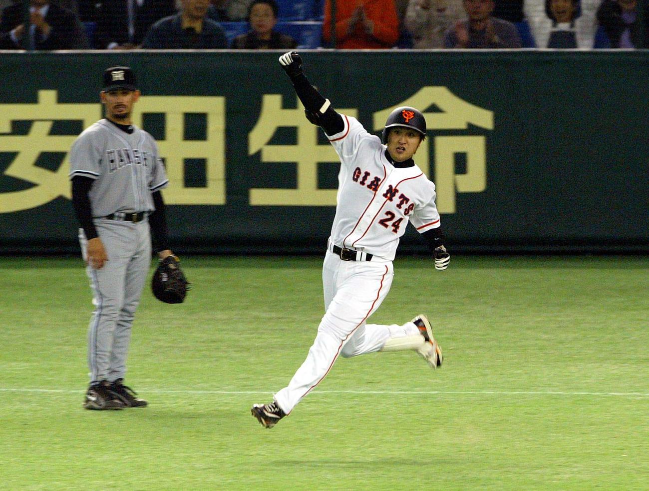 03年4月11日、阪神戦の延長12回、同点本塁打を放ちガッツポーズの巨人高橋。左はアリアス