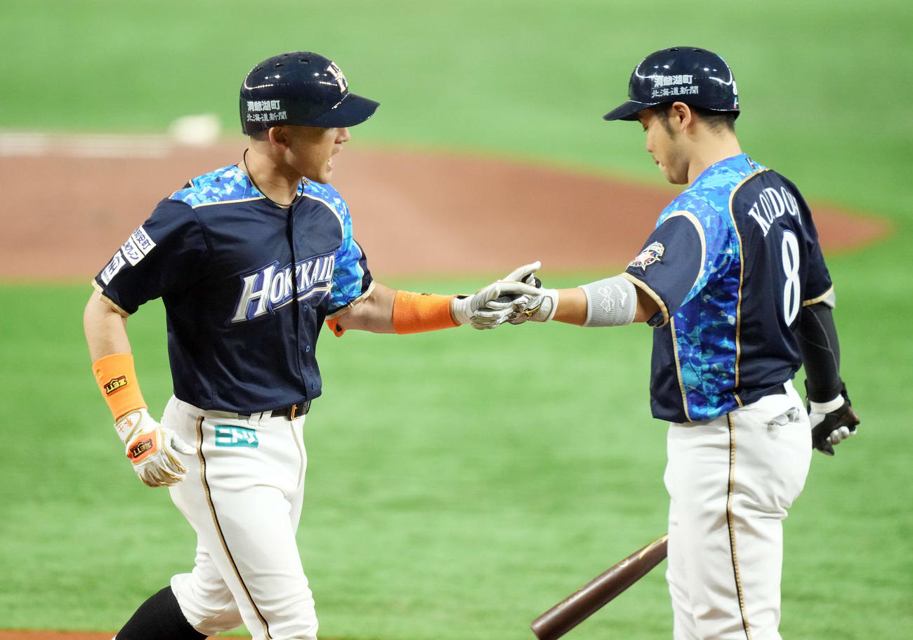 日本ハム対オリックス　1回裏日本ハム1死、左越えソロ本塁打を放ち生還する杉谷（左）（撮影・鈴木みどり）