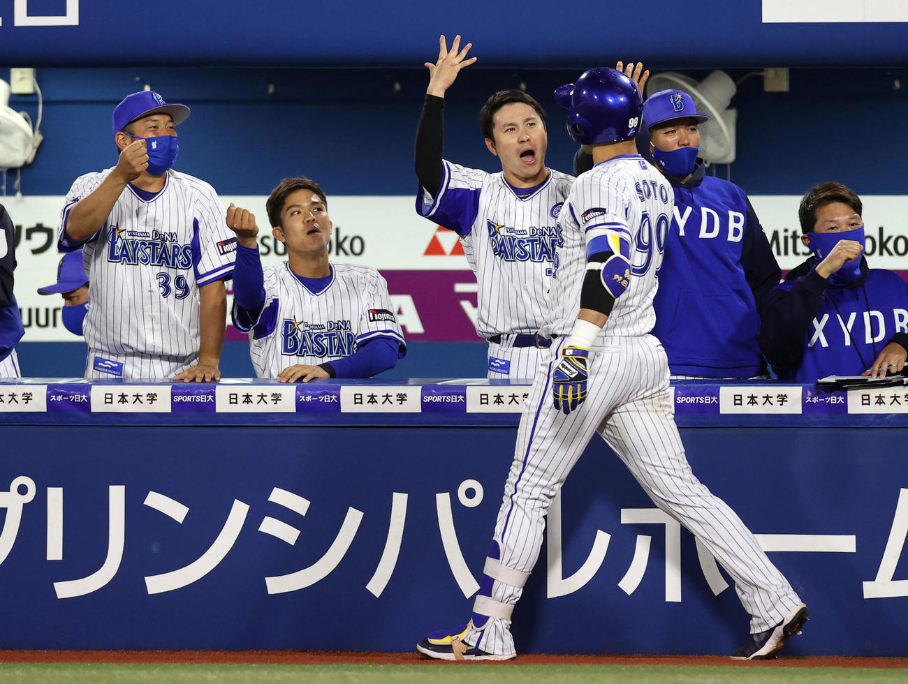 DeNA対巨人　8回裏DeNA2死一塁、2点本塁打を放ったソト（手前）を迎える佐野（中央）らDeNAベンチ（撮影・狩俣裕三）