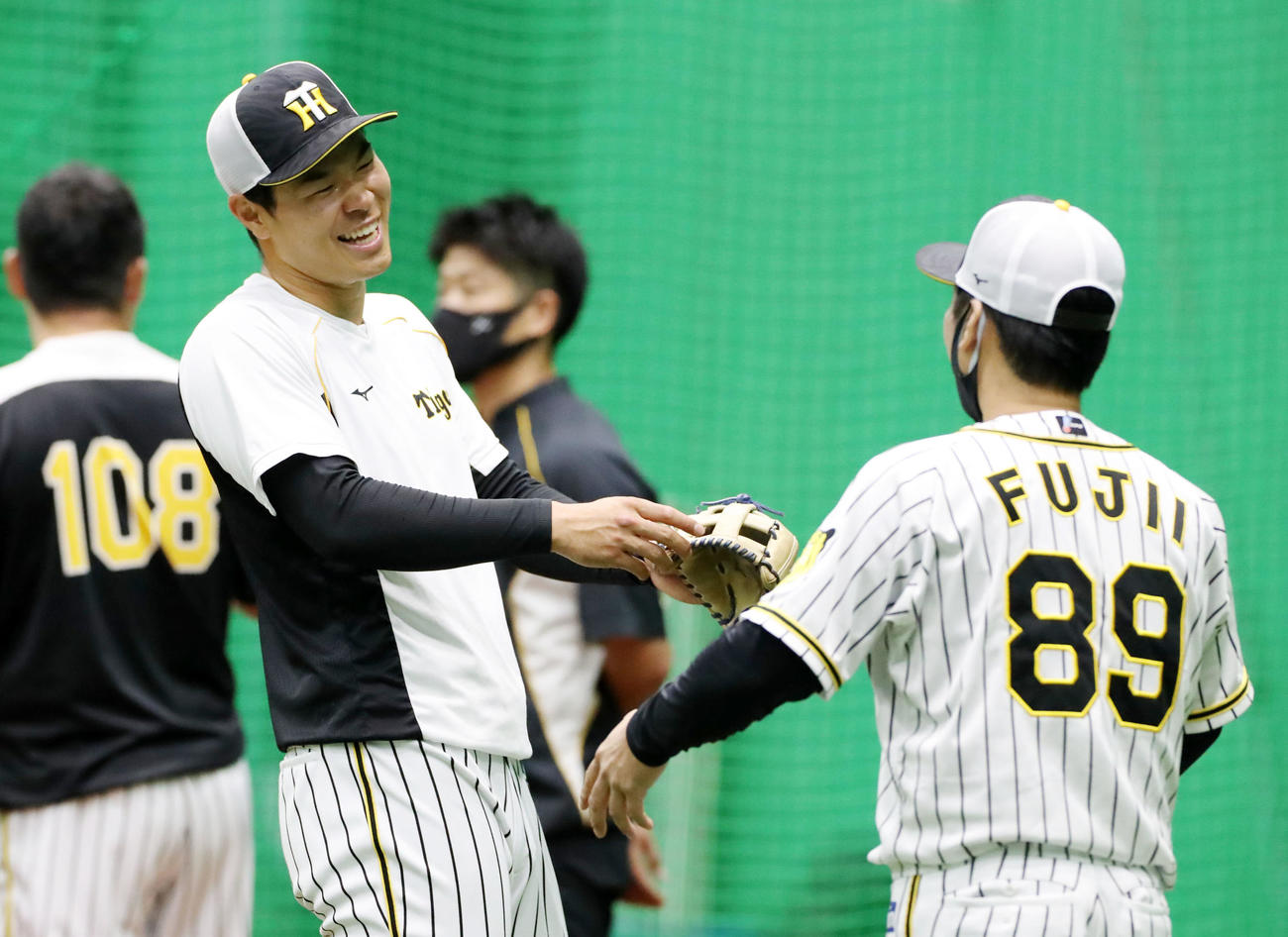 藤井コーチ（右）と談笑する佐藤輝（撮影・加藤哉）