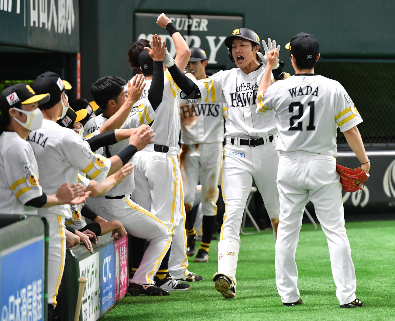 ソフトバンク対ロッテ　3回裏ソフトバンク2死二塁、右越え2点本塁打を放った柳田（右から2人目）は和田（右端）らナインとタッチを交わす（撮影・岩下翔太）
