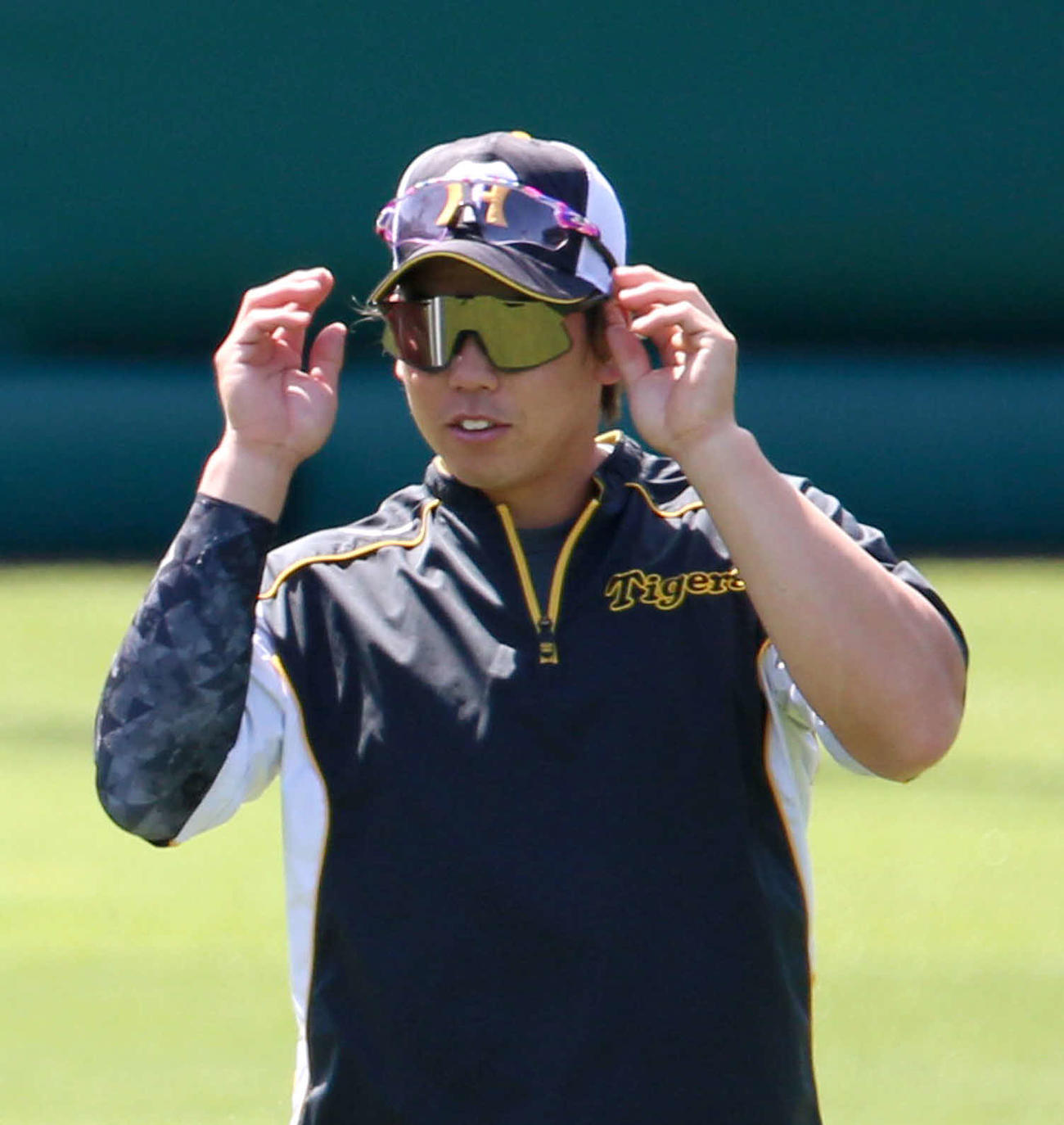 佐藤輝のサングラスを試す梅野（撮影・上山淳一）