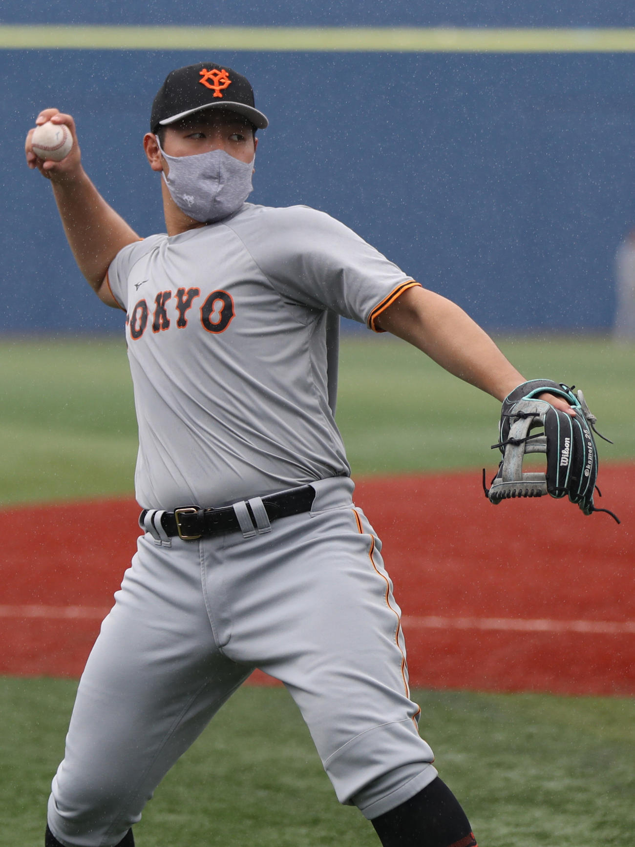 DeNA対巨人　雨の横浜スタジアムでキャッチボールをする岡本和（撮影・狩俣裕三）