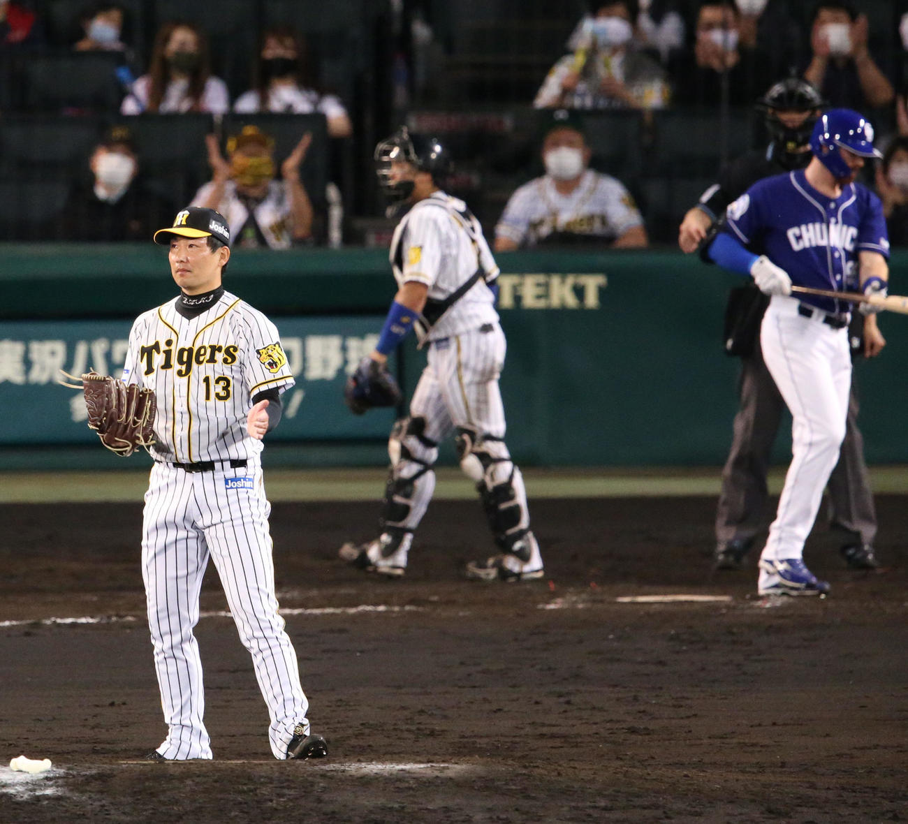阪神対中日　8回表中日2死三塁、岩崎（手前）はガーバーを空振り三振に仕留めグラブをたたき喜ぶ（撮影・上山淳一）