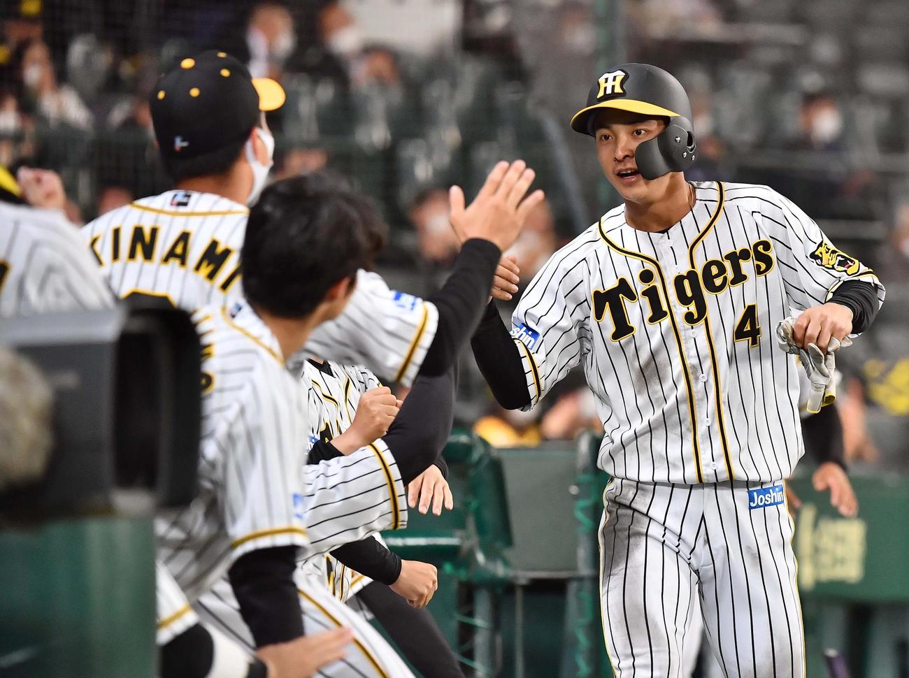 阪神対中日　7回裏阪神2死二塁、近本の中前同点適時打で生還しナインに迎えられる熊谷（撮影・上田博志）
