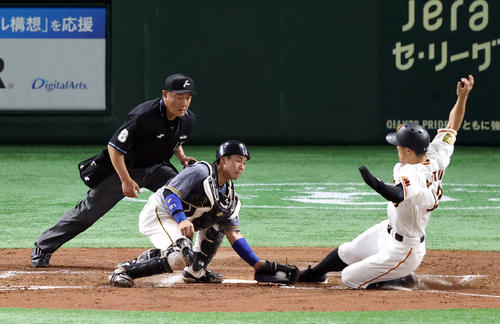 巨人対阪神　3回裏巨人1死満塁、岡本和の犠飛で生還する梶谷（右）。左は梅野（撮影・狩俣裕三）