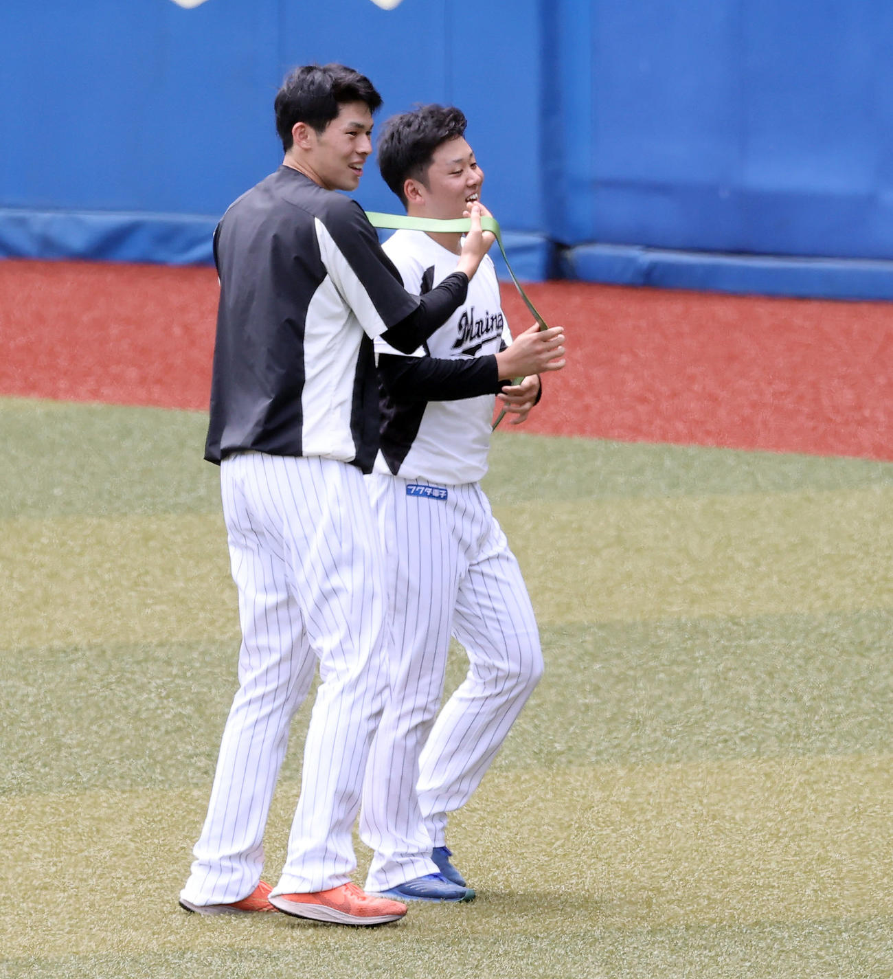ロッテ対西武　試合前練習、ロッテ佐々木朗（左）はたすきのようなチューブを鈴木にかける（撮影・垰建太）