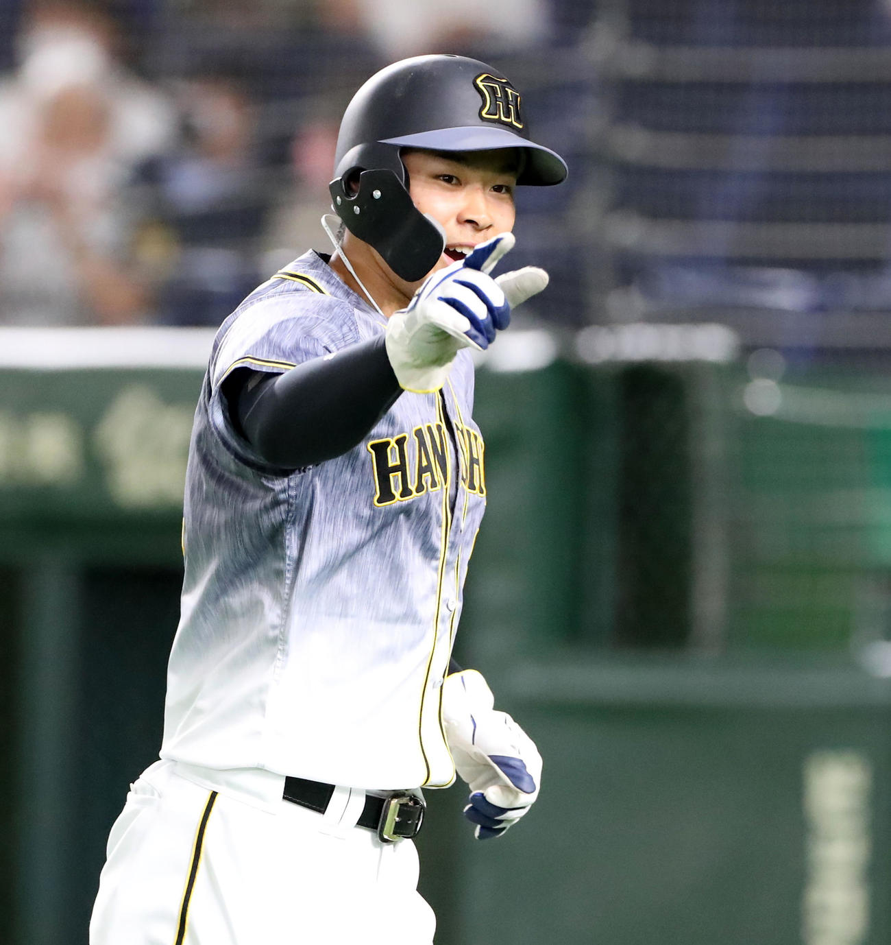巨人対阪神　1回表、先制適時二前打を放った佐藤輝は、攻守交代でナインにポーズを決める（撮影・加藤哉）