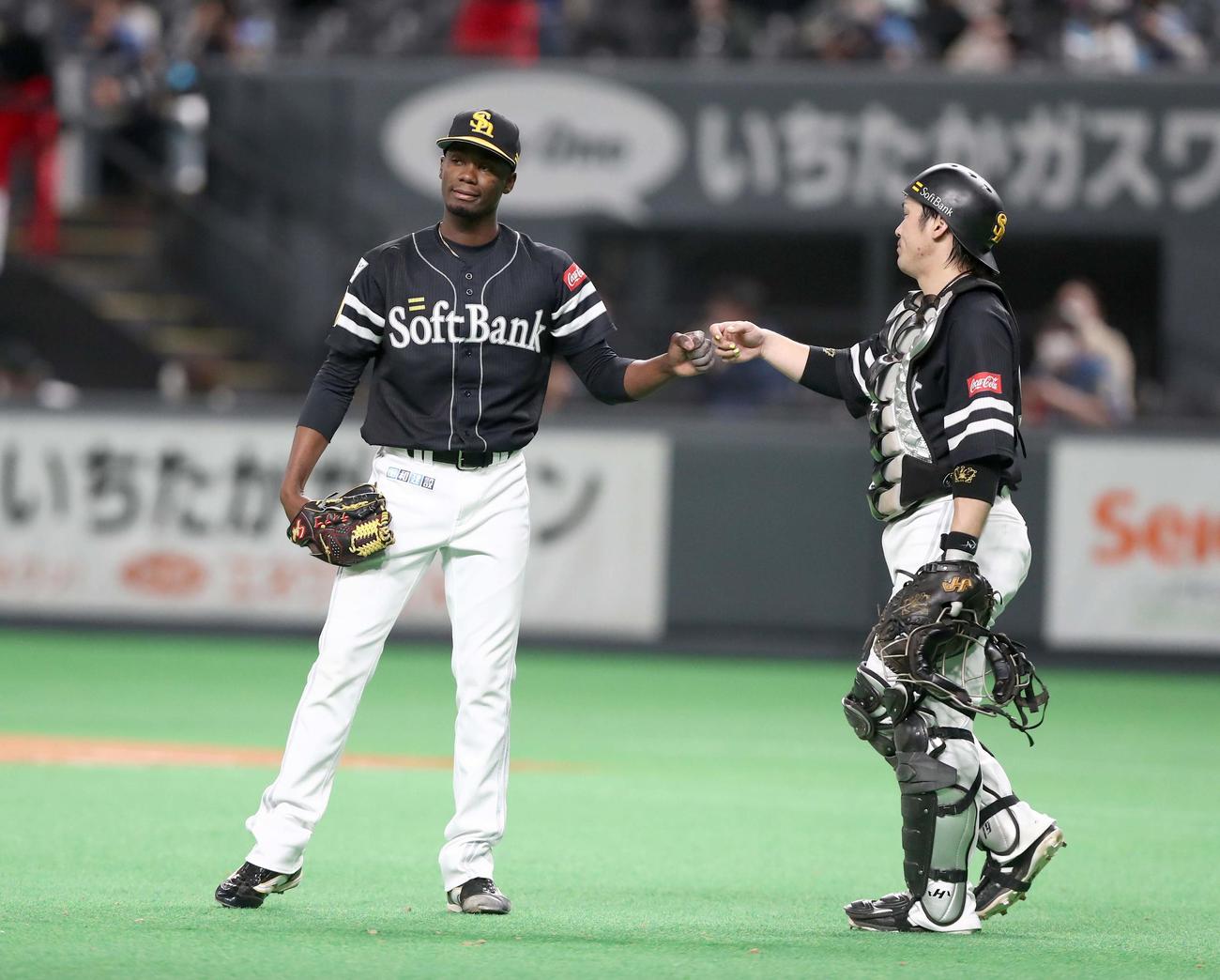 日本ハム対ソフトバンク　試合後、甲斐（右）とタッチするモイネロ（撮影・黒川智章）