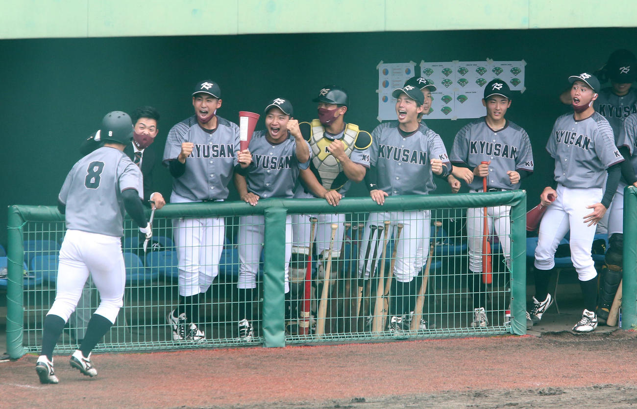 九共大対九産大　2回表九産大1死一塁、右越え2点本塁打で生還した中村貴浩（左）を祝福する九産大ナイン（撮影・菊川光一）