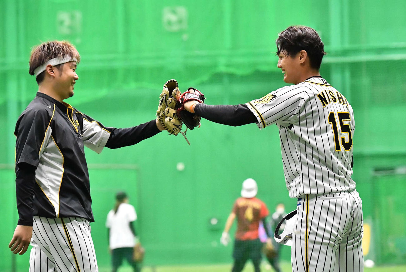キャッチボールを終え笑顔を見せながらグラブタッチする西勇（左）と西純（撮影・上田博志）