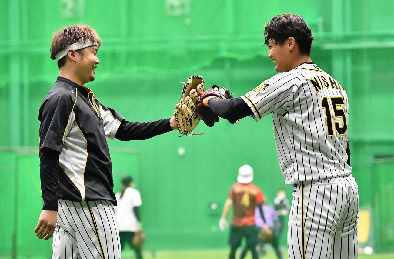 キャッチボールを終え笑顔を見せながらグラブタッチする西勇（左）と西純（撮影・上田博志）