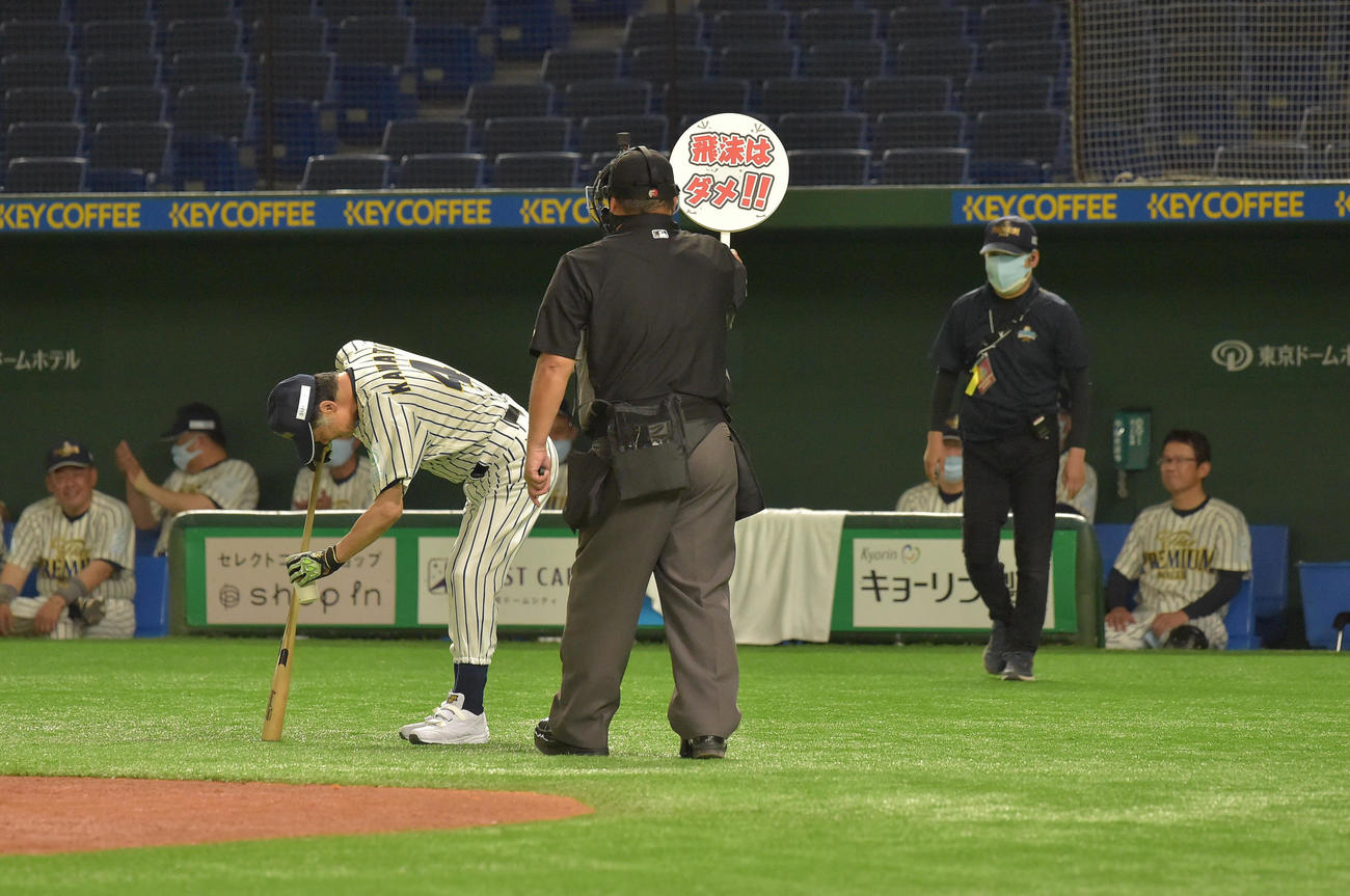 「サントリー　ドリームマッチ2021」で打席に向かうザ・プレミアム・モルツ球団の川藤幸三氏（左）は審判から「飛まつはダメ！！」と書かれたボードで注意を受ける