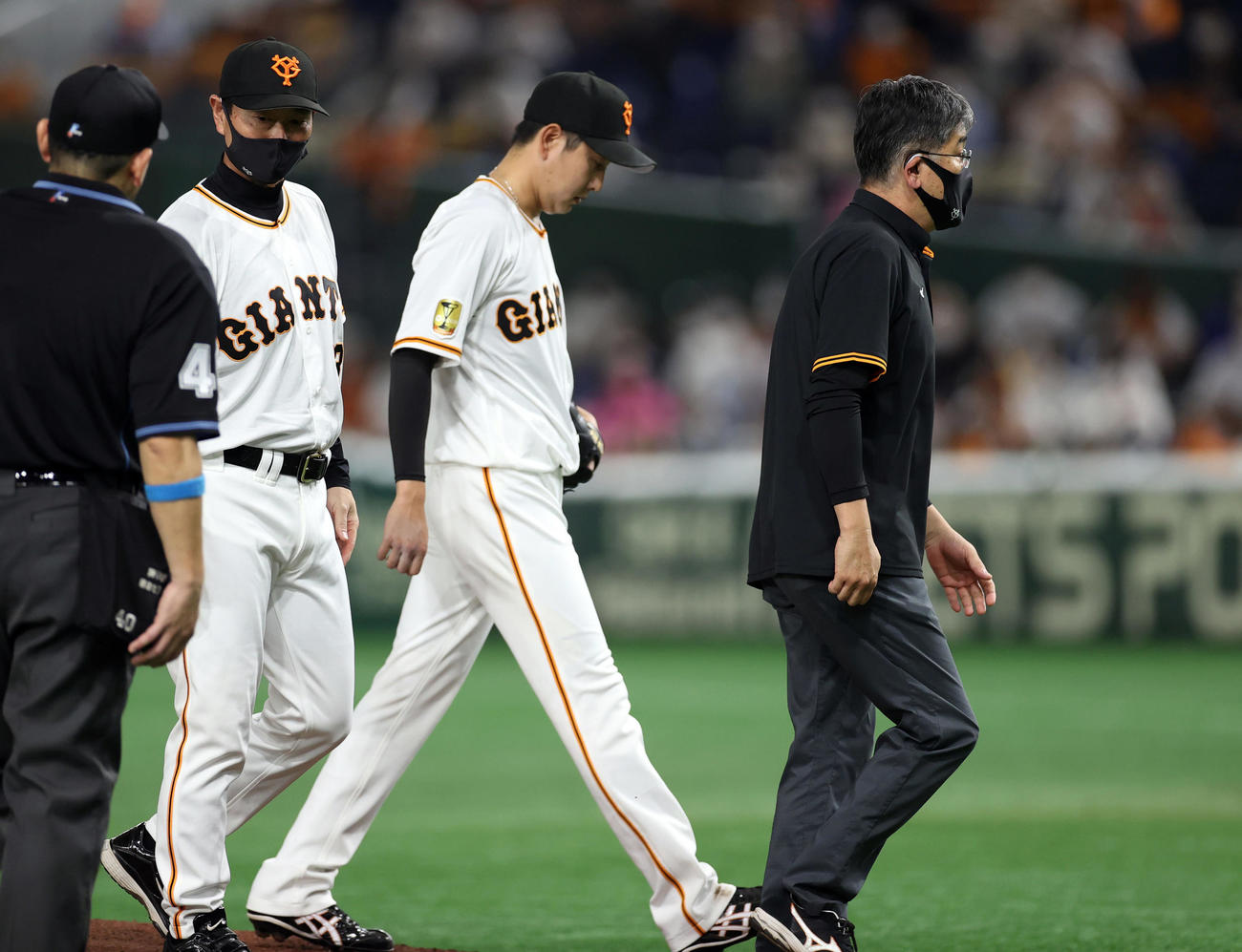 巨人対広島　7回表途中、降板する野上（中央）。左は桑田投手チーフコーチ補佐（撮影・狩俣裕三）