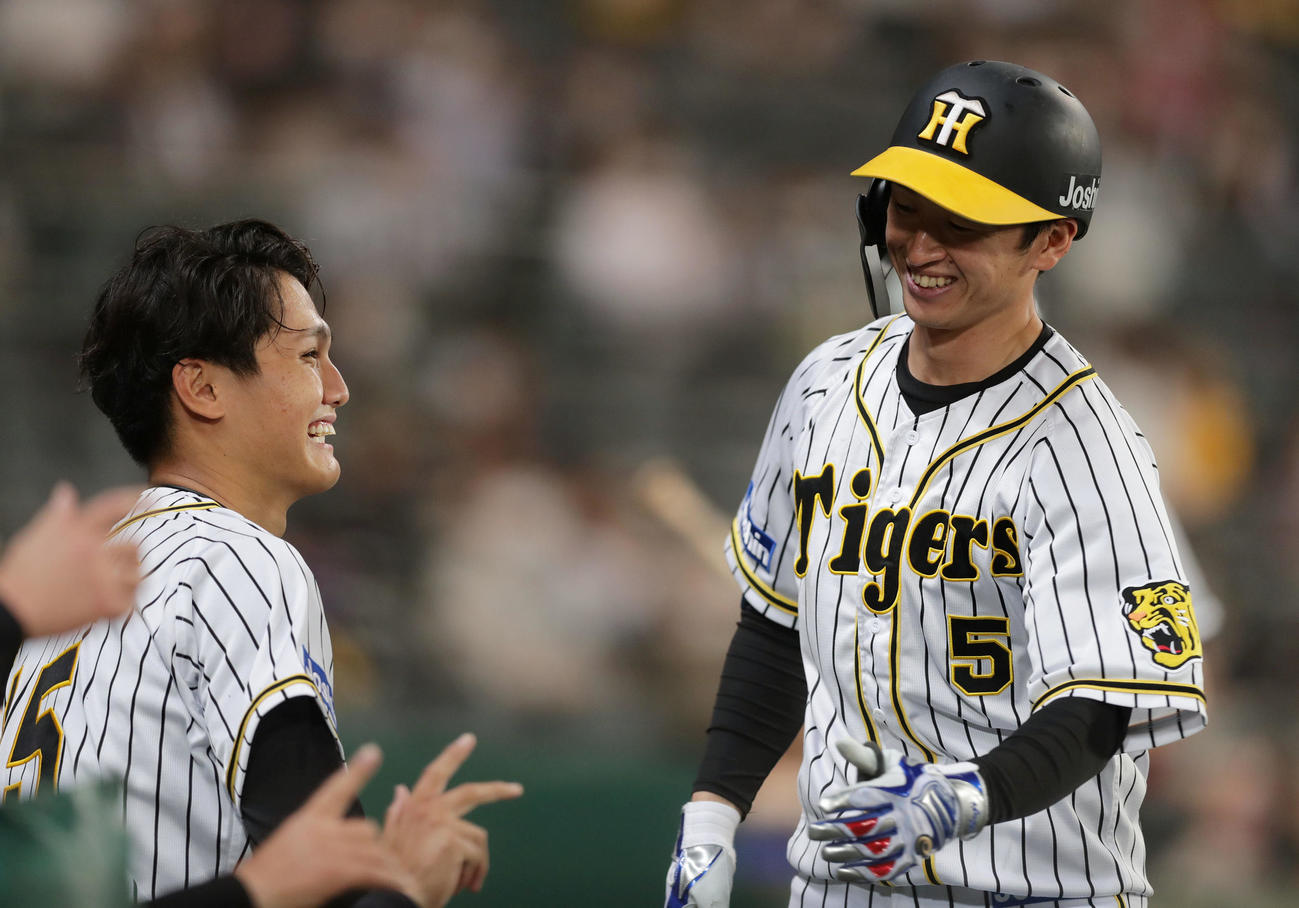 阪神対ヤクルト　5回裏阪神1死、右越え先制本塁打を放った近本（右）を笑顔で迎える西純（撮影・前田充）