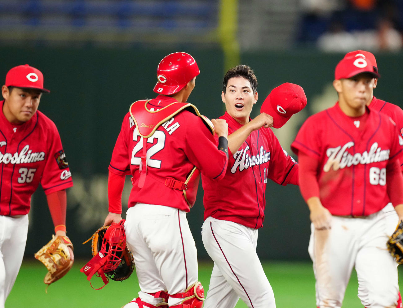 巨人対広島　9回6安打2失点で完投勝利を挙げ広島捕手中村奨（中央左）とタッチをかわす九里（撮影・江口和貴）