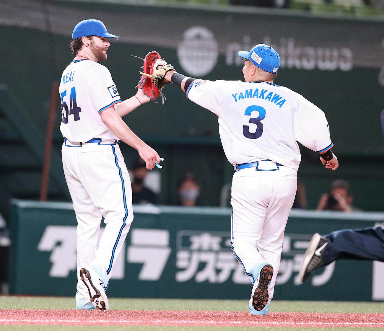 6回表ソフトバンクの攻撃を抑えたニール（左）は山川と笑顔でグラブタッチ（撮影・浅見桂子）