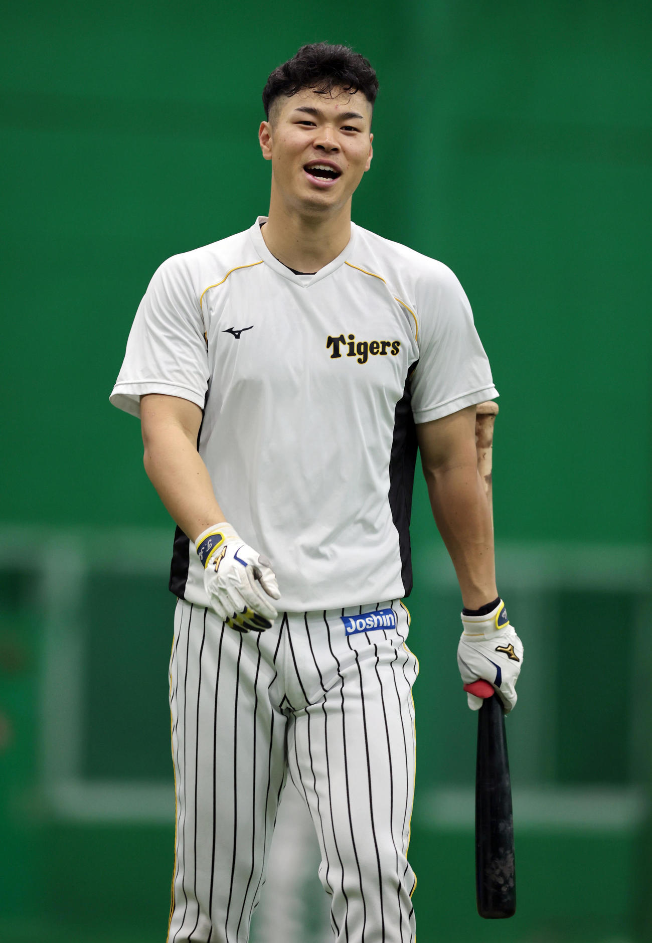 室内練習場で笑顔を見せる佐藤輝（撮影・前田充）