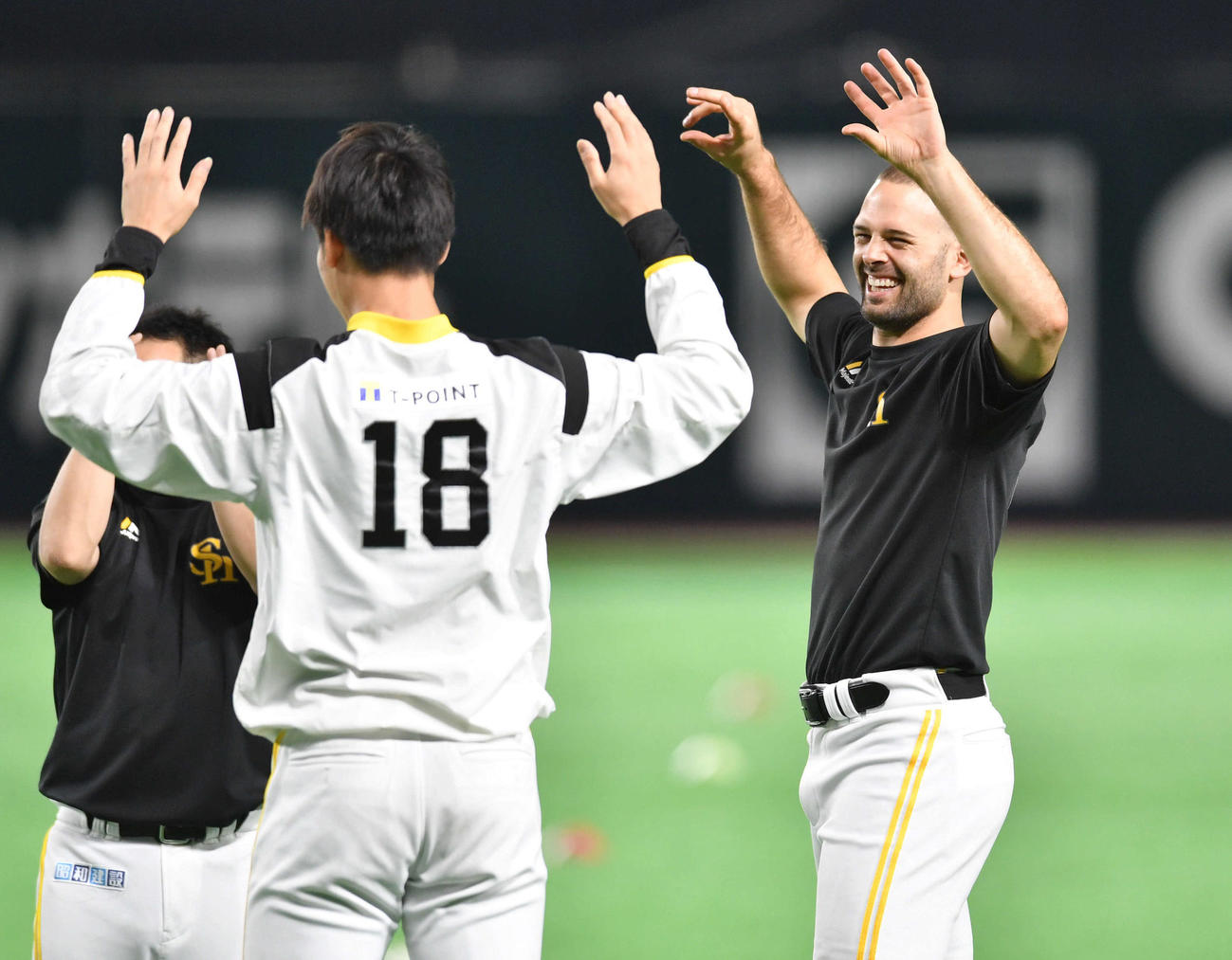 武田（左）ら投手陣と談笑しながらウオーミングアップを行うマルティネス（撮影・岩下翔太）