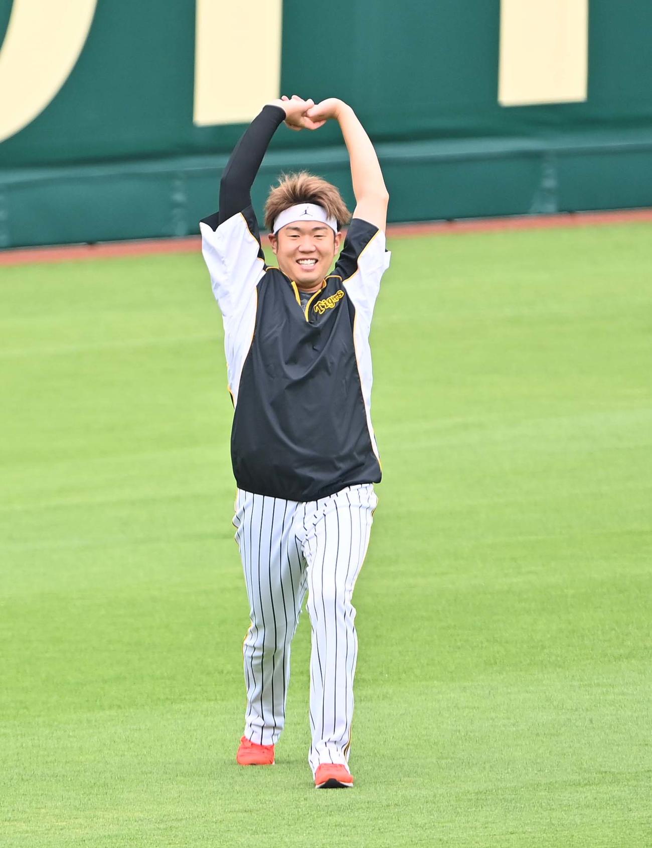 笑顔でストレッチする西勇（撮影・上田博志）