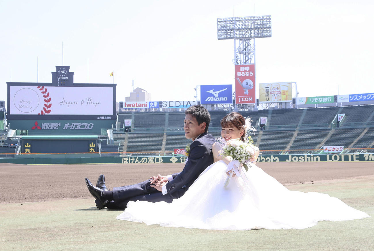 甲子園球場で笑顔いっぱいにウェディングフォトする堀北勇人さんと新婦の麻由さん（撮影・上山淳一）