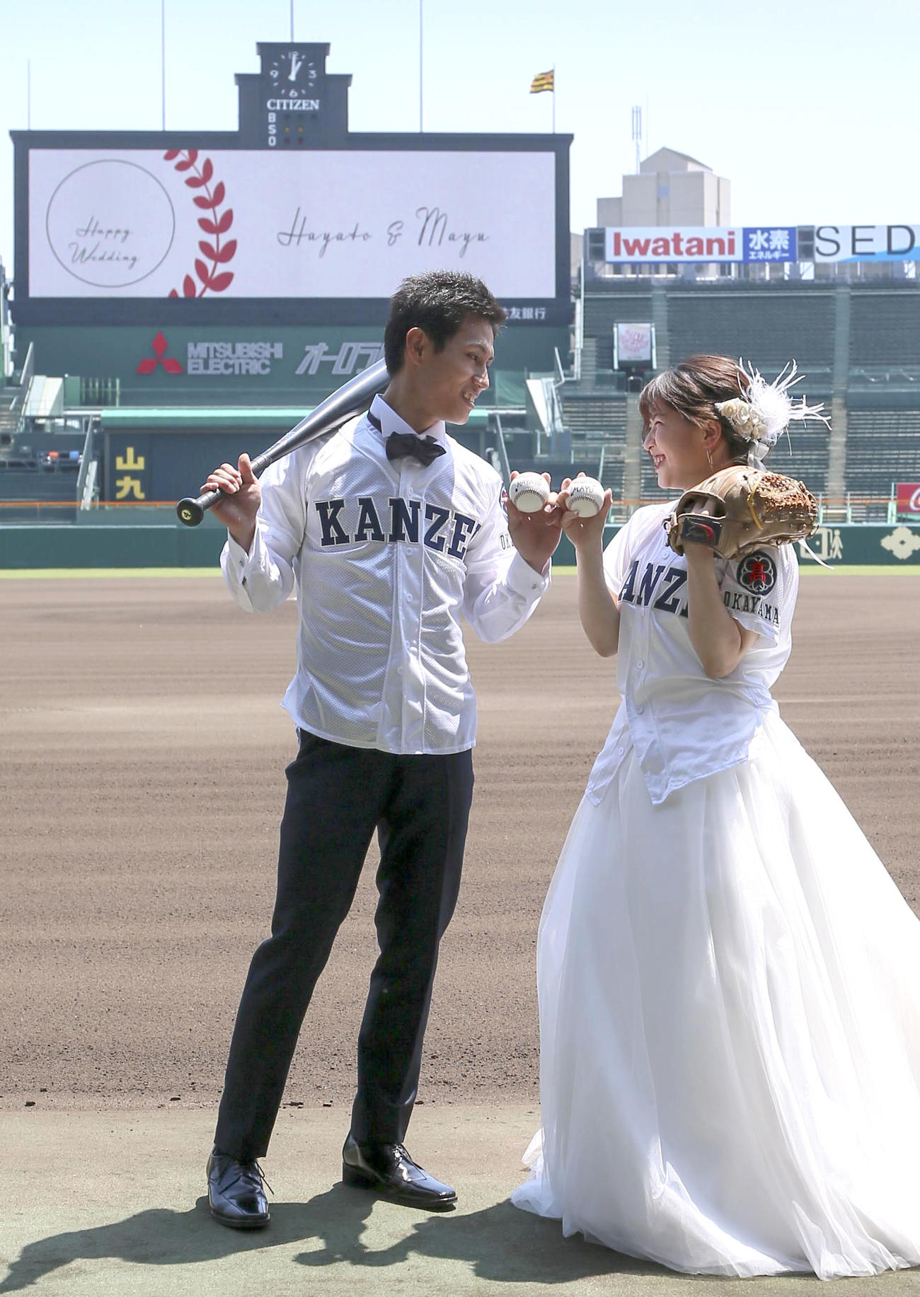 甲子園球場で笑顔いっぱいにウェディングフォトする堀北勇人さんと新婦の麻由さん（撮影・上山淳一）