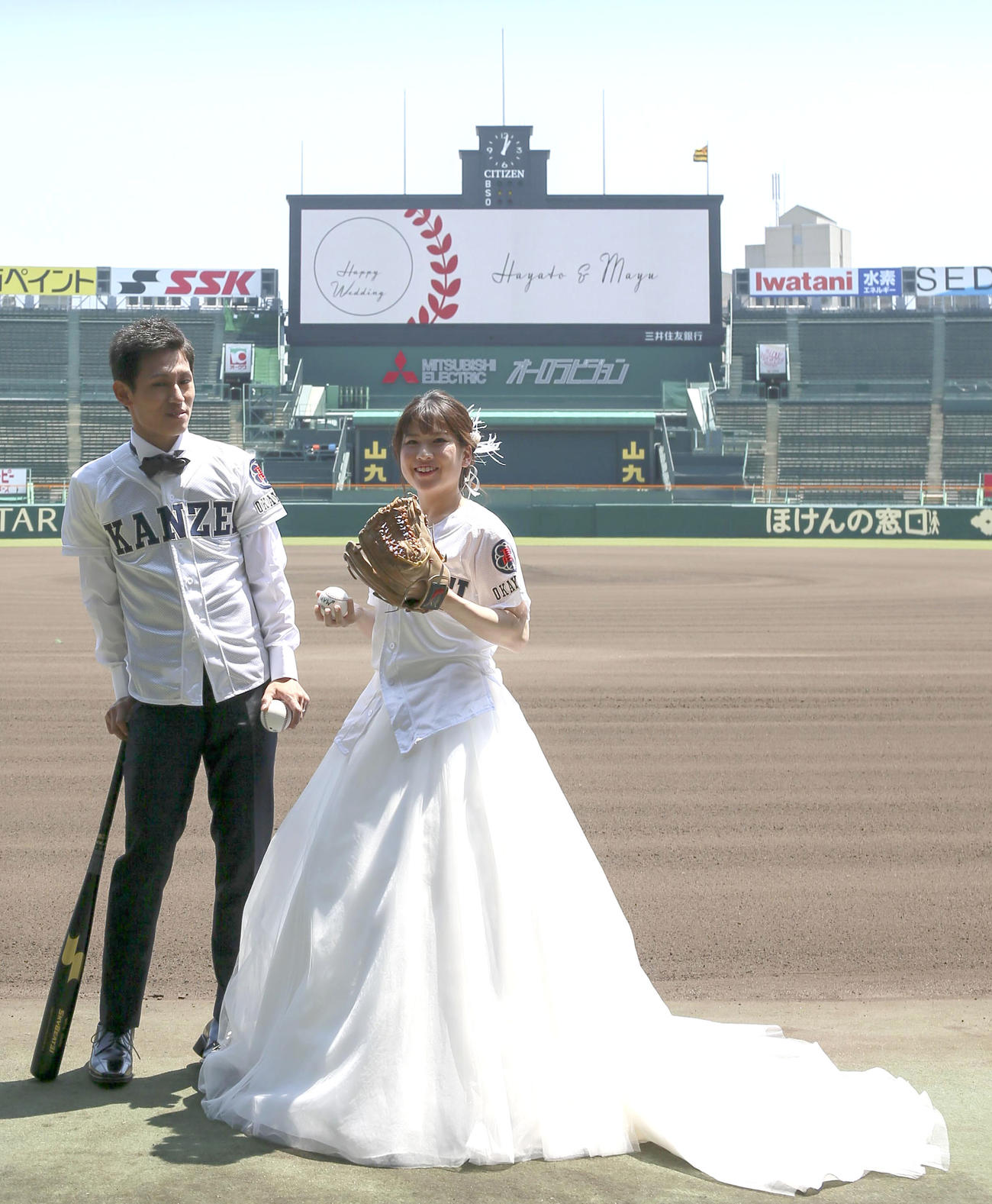 甲子園球場で笑顔いっぱいにウェディングフォトする堀北勇人さんと新婦の麻由さん（撮影・上山淳一）